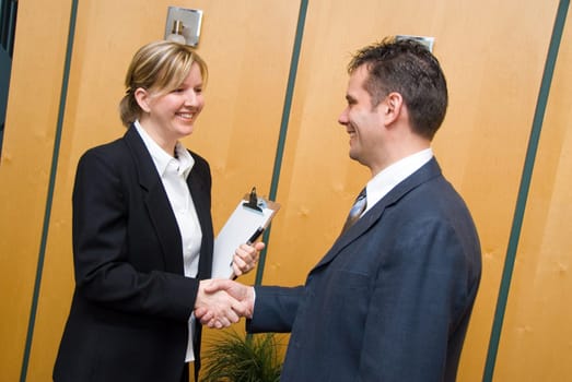 man and woman greeting each other in a reception area