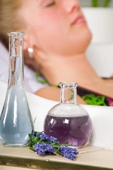 blond woman in a spa bath relaxing with focus on oils