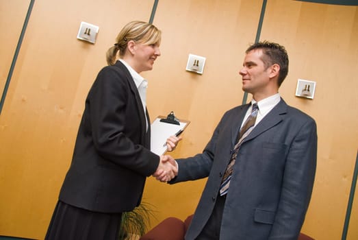 man and woman greeting each other in a reception area