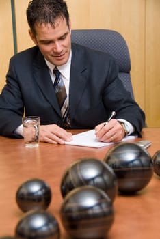businessman in a room writing on paper