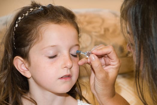 Young girl getting her makeup done before the wedding