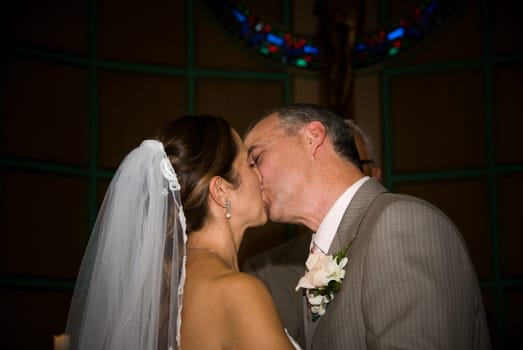 A bride and a groom kissing in a church