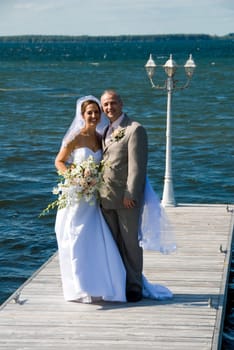 a just married man and woman by a lake