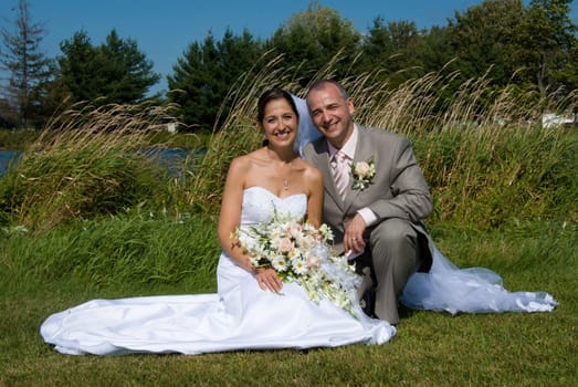 a just married man and woman by a lake
