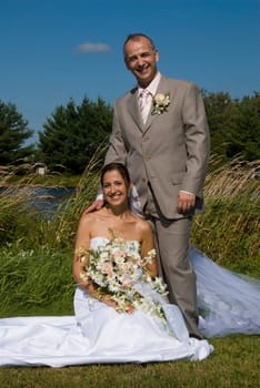 a just married man and woman by a lake