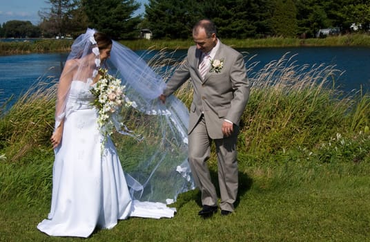 a just married man and woman by a lake