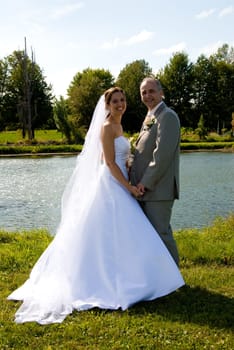 a just married man and woman by a lake