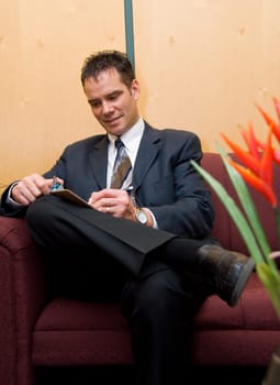 business man taking notes in a reception area