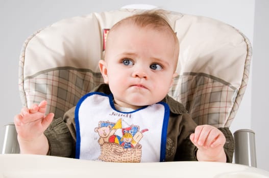 cute baby in a long chair ready to eat