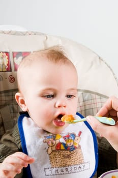 parent feeding a cute baby healthy food