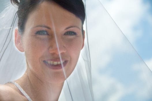 White Bride at her wedding posing with veil