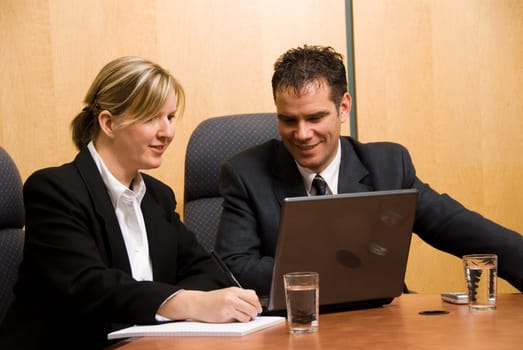 business colleagues in a borad room with a laptop