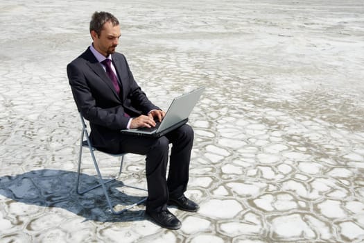 Photo of modern businessman typing on laptop outside