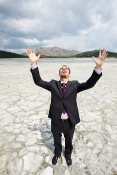 Photo of elegant businessman standing and raising his arms outdoors in summer