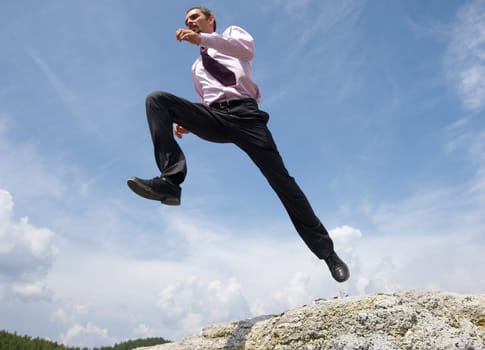 Image of running man on background of bright blue sky with white clouds