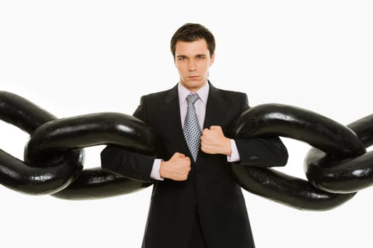 Portrait of powerful businessman with several sections of huge chain over white background
