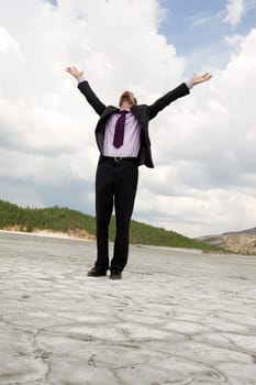 Photo of elegant businessman standing and raising his arms outdoors in summer