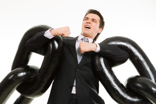 Portrait of tense businessman with two sections of heavy chain over white background