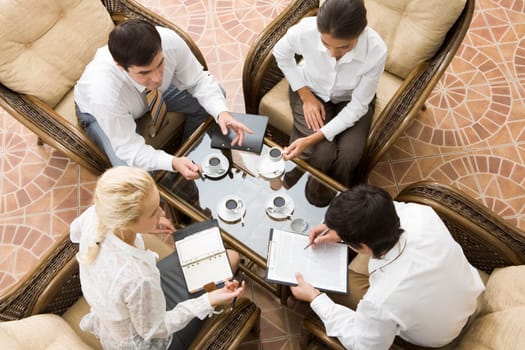 View from above of four businesspeople discussing work