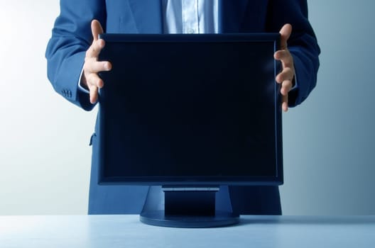 businessman holding an lcd monitor