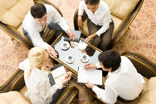 View from above of four businesspeople discussing work