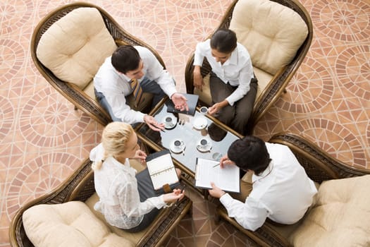 View from above of four businesspeople discussing work