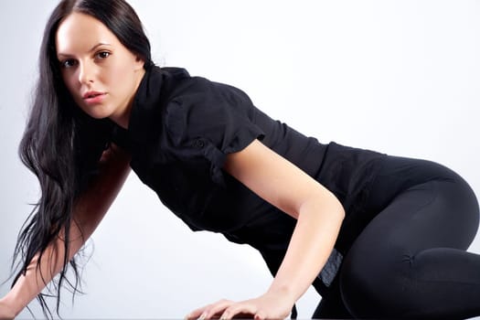 Portrait of young woman in black clothes against white background
