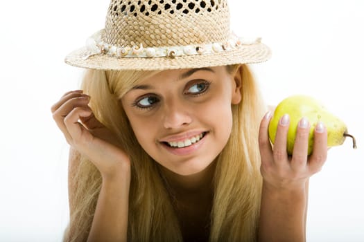 Smiling young sensual blond girl in summer hat is holding a pear