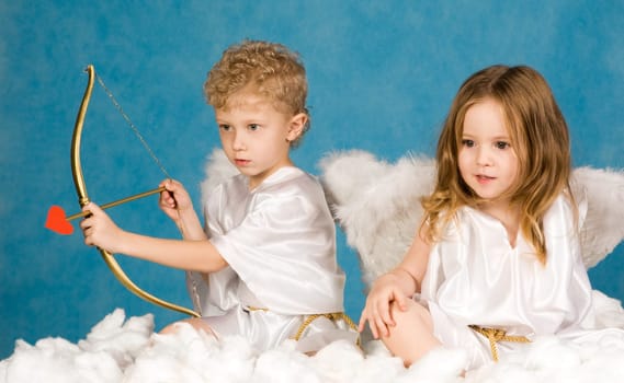 Portrait of two young angels sitting on the cloud