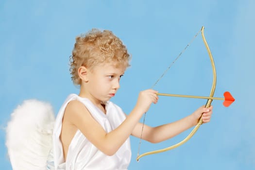 Portrait of little boy with bow and arrow ready to make someone fall in love