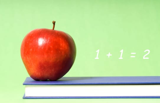 apple on green background on blue book