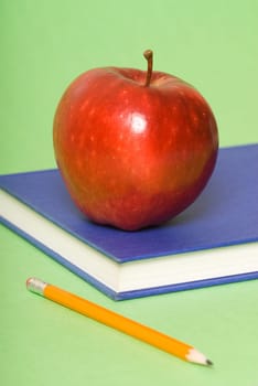 blue book with red apple and pencil