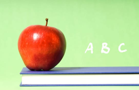apple on green background on blue book