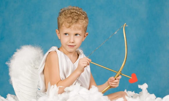 Portrait of little boy with bow and arrow ready to make someone fall in love