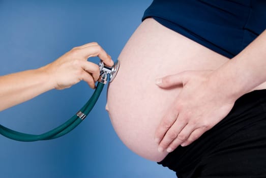 a doctor listening to a pregnant woman's belly