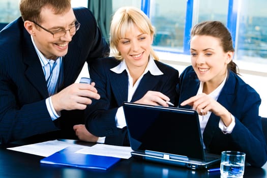 Team of three confident people gathered together for discussing a business-plan