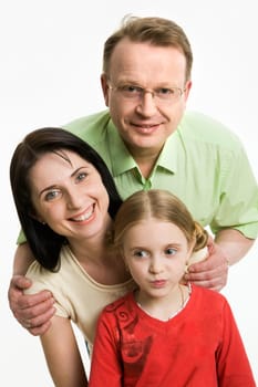 Image of father, mother and their daughter looking at camera and smiling