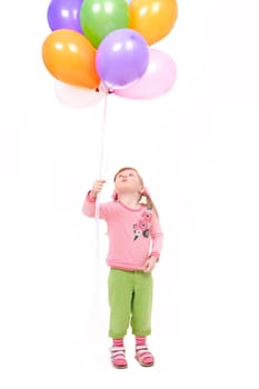 Image of small girl with helium balloons looking upwards at them