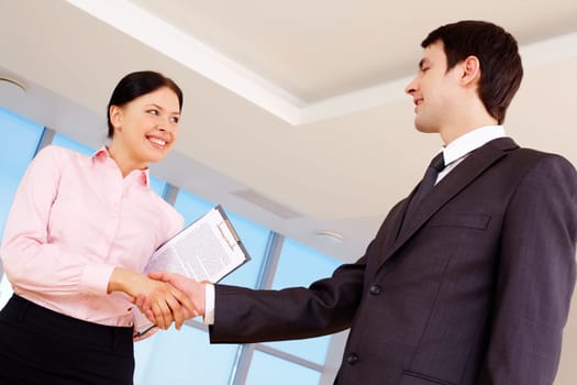 Photo of partners handshaking after signing contract
