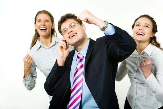 Portrait of three business partners holding their arms up and looking upwards with businessman speaking on the phone