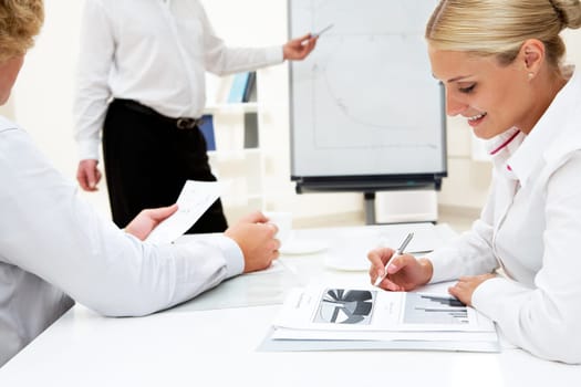 Close-up of businesspeople on background of senior boss explaining his idea by the board