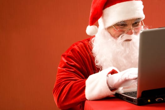 Photo of Santa Claus typing e-mail message of congratulation
