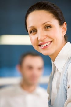 Portrait of happy businesswoman smiling at camera on background of man