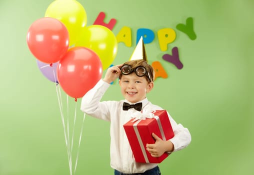 Portrait of happy lad with giftbox putting off funny eyeglasses on birthday party