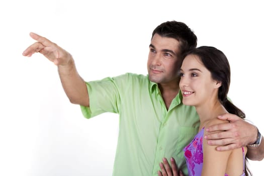 Handsome man embracing pretty woman while both looking at something over white background