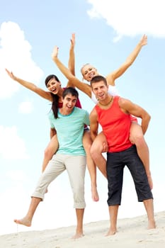Happy company of two young men and two women on their backs