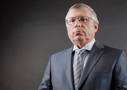 Photo of senior employer looking at camera on black background