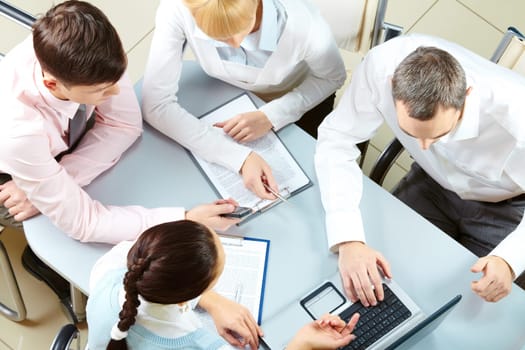 Above view of friendly workteam discussing business plan