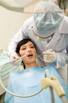 Photo of pretty girl with the dentist over her holding drilling instrument and mirror