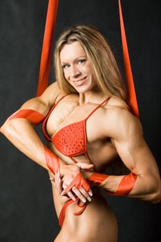 Portrait of strong female in red bikini smiling and looking at camera